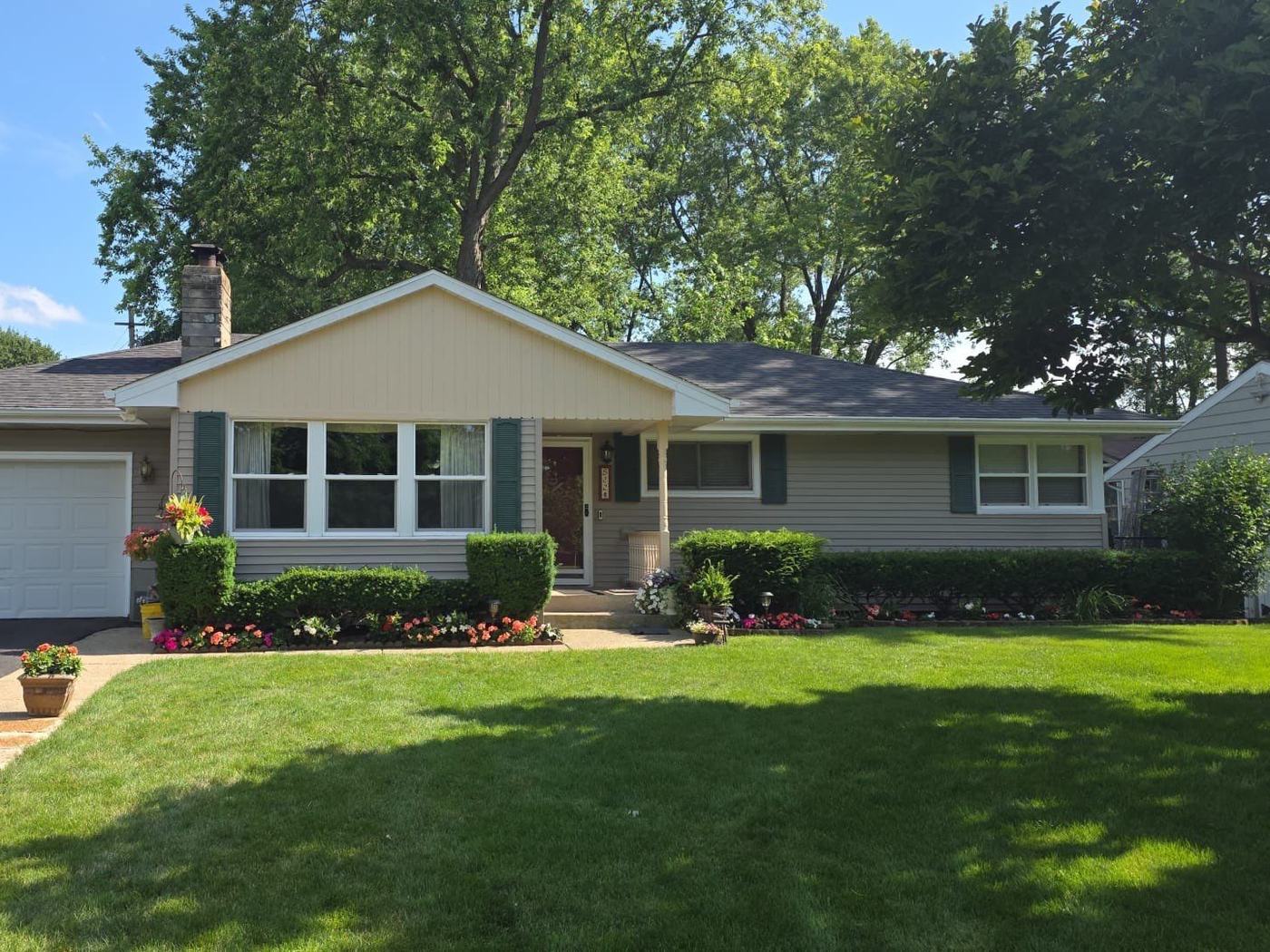 Ranch home in the Dundee area with a new gray roof and flower beds